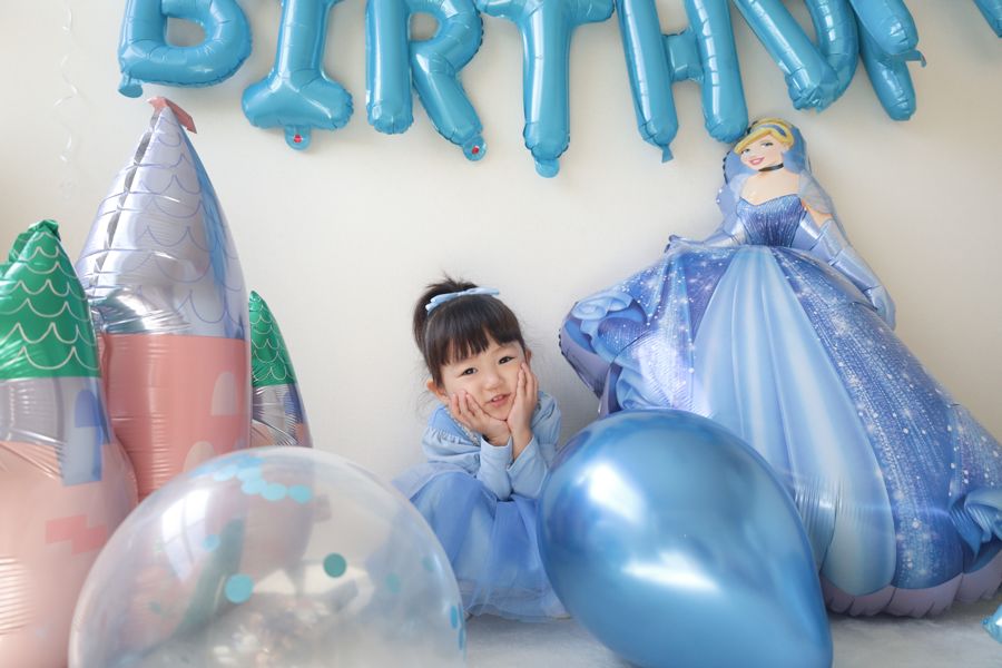 水色のBIRTHDAY文字バルーンとシンデレラのアルミバルーンを壁ぎわに並べた誕生日の飾り付け