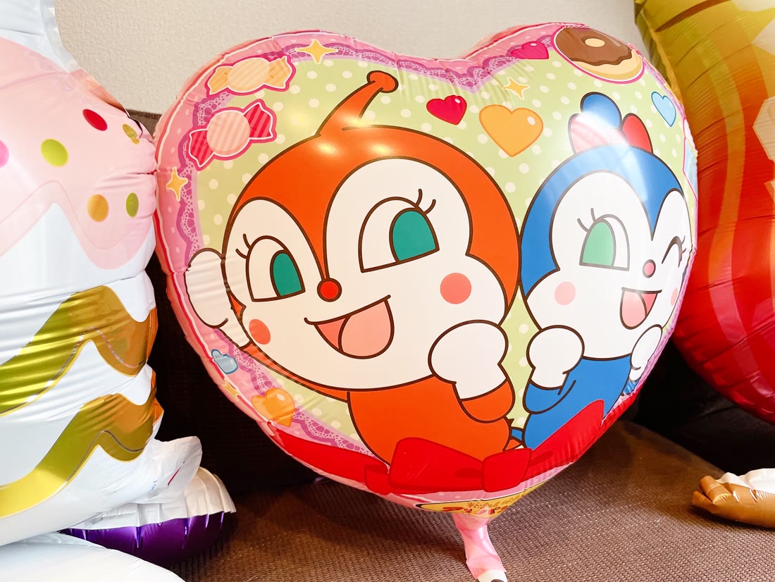 ドキンちゃんとコキンちゃんが描かれたスイーツ柄のハート型バルーンのクローズアップ