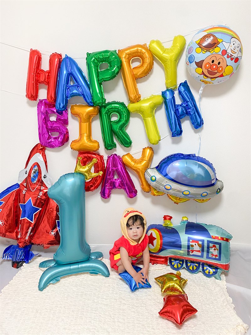 アンパンマンの衣装を着た1歳の子とアンパンマン公式バルーン・乗り物バルーンの誕生日実例