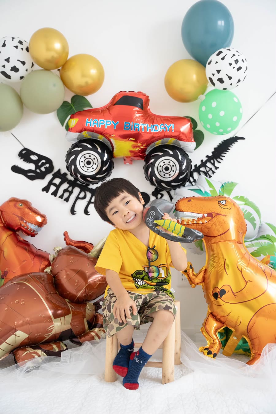 恐竜バルーンセットで飾り付けした誕生日。剣を持った男の子にティラノサウルスのバルーンが噛みつく実例写真