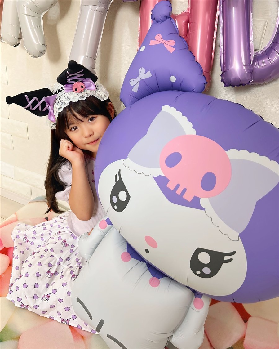 クロミのカチューシャを付けた女の子が、高さ80cmの特大クロミバルーンにほおづえをついて写る誕生日実例
