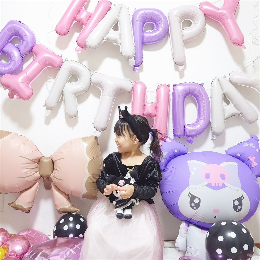 クロミのぬいぐるみを抱えた女の子と特大クロミバルーンの誕生日飾り付け